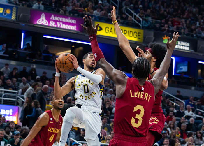 Dec 29, 2022; Indianapolis, Indiana, USA; Indiana Pacers guard Tyrese Haliburton (0) passes the ball while Cleveland Cavaliers guard Caris LeVert (3) defends at Gainbridge Fieldhouse. Mandatory Credit: Trevor Ruszkowski-USA TODAY Sports